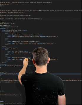 Simon standing with back to the camera and one arm extended forward with a screwdriver in his hand. Behind him on a black background is white text that is code from an HTML page.